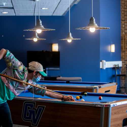 A student plays pool in the Kirkhof center