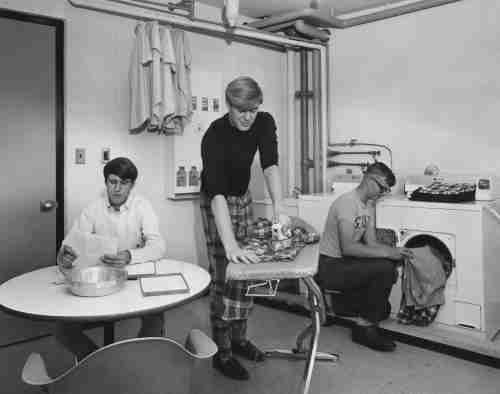 Black and white archive photo showing students in the Copeland laundry room ironing and doing laundry