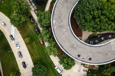Cars wait in line near a curvy shaped living center during move-in week.