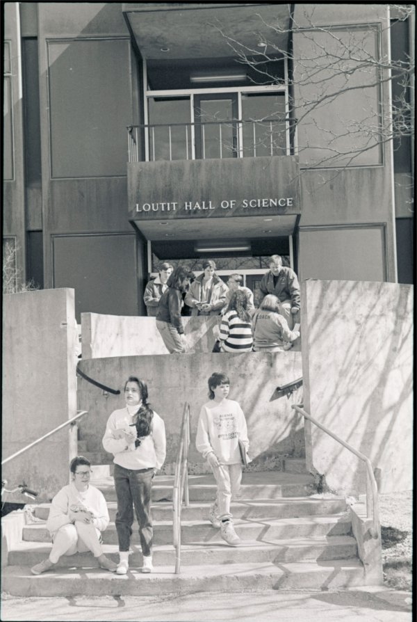 Students sit and stand in front of Loutit Hall of Science in a photo from 1991.
