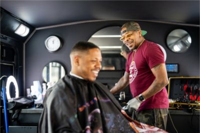 Cecil Jackson gives a haircut in his barber van