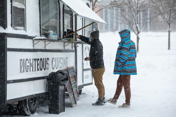 Two people order from the Righteous Cuisine food truck outside the Kirkhof Center on the GVSU Allendale Campus.