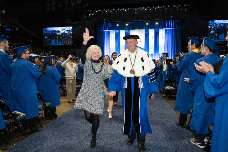 President Haas and Marcia Haas walking down aisle at commencement.