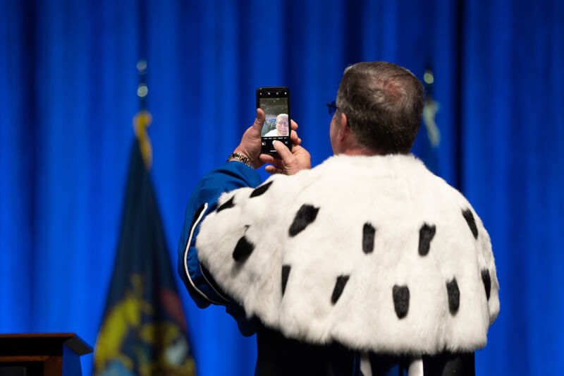 President Haas taking selfie on stage