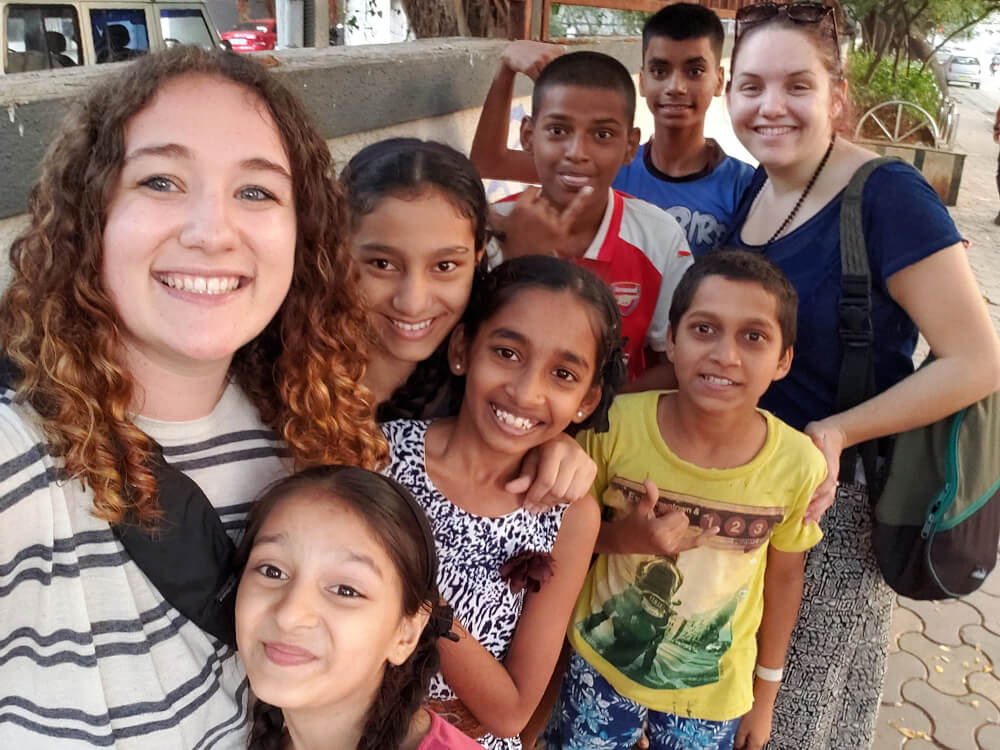 young woman takes selfie with group of students in India