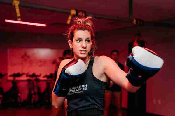 A college student worker teaches a kickboxing class.