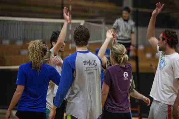 Students high five after an intramural volleyball game.