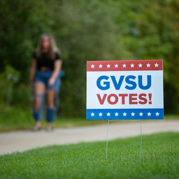 A red, white and blue sign that reads: GVSU Votes! with stars