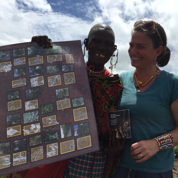 Kristin Hedges (right) pictured delivering her catalog to local healers in the Maasai community.