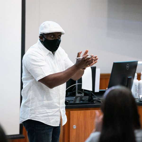 Felix Ngassa teaching in front of students in mask.