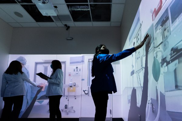 Students inside a lab with interactive walls and floors.