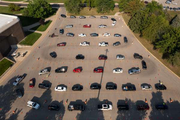 Many cars line up in a parking lot.
