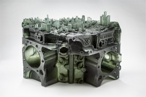 glasswork, skyline of Detroit placed atop a V8 engine