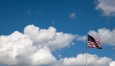 American flag flies over blue, cloudy sky