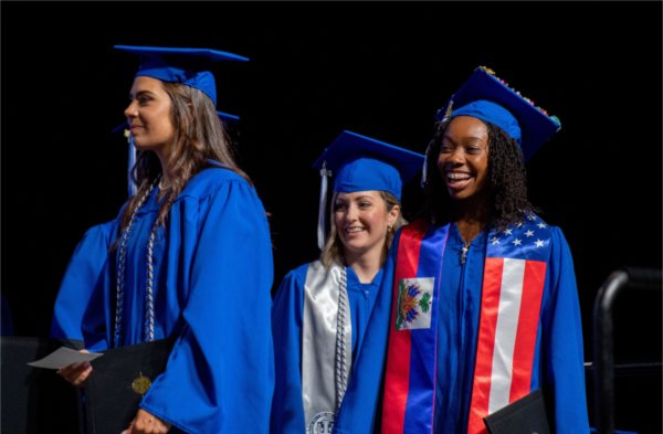    Graduates smile after receiving their diplomas. 