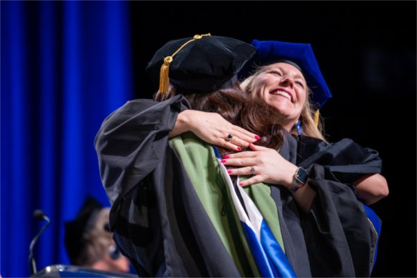  A faculty member hugs a graduate.