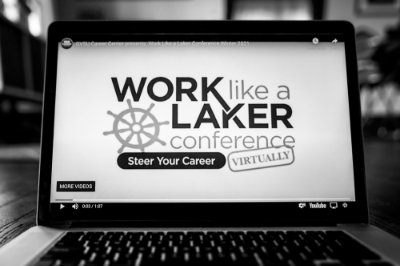 A black and white photo of a computer screen that shows text that reads work like a laker conference, steer your career virtually