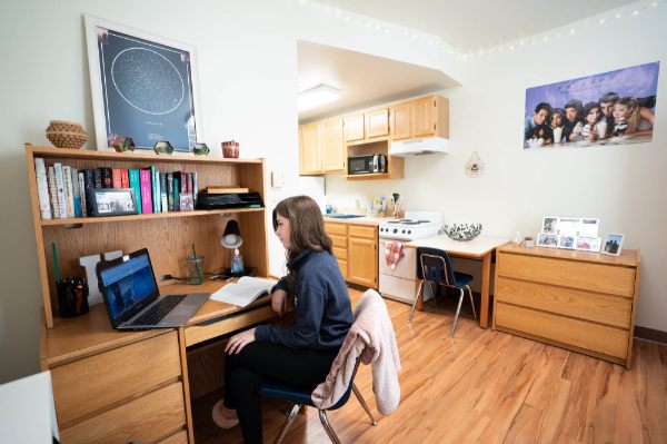 Holly Cookson-Martinez sits at a desk in her Winter Hall room.