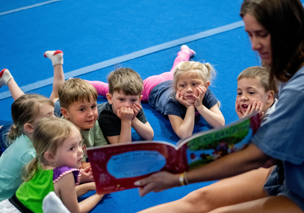 Student reading to children.
