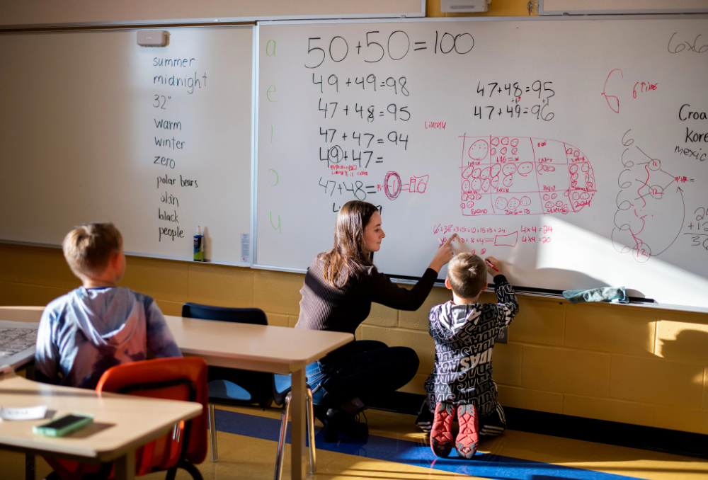 At left, Katelyn Meyer, a GVSU sophomore, works out a math problem with a third grader at Evergreen Elementary School in Allendale.
