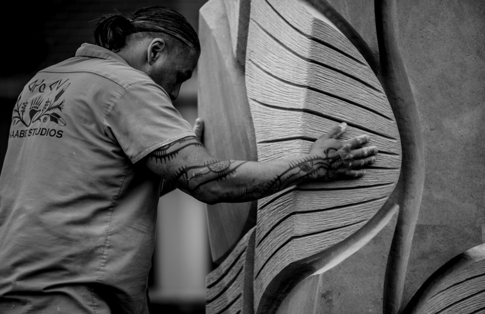 A Native American artist and his sculpture.
