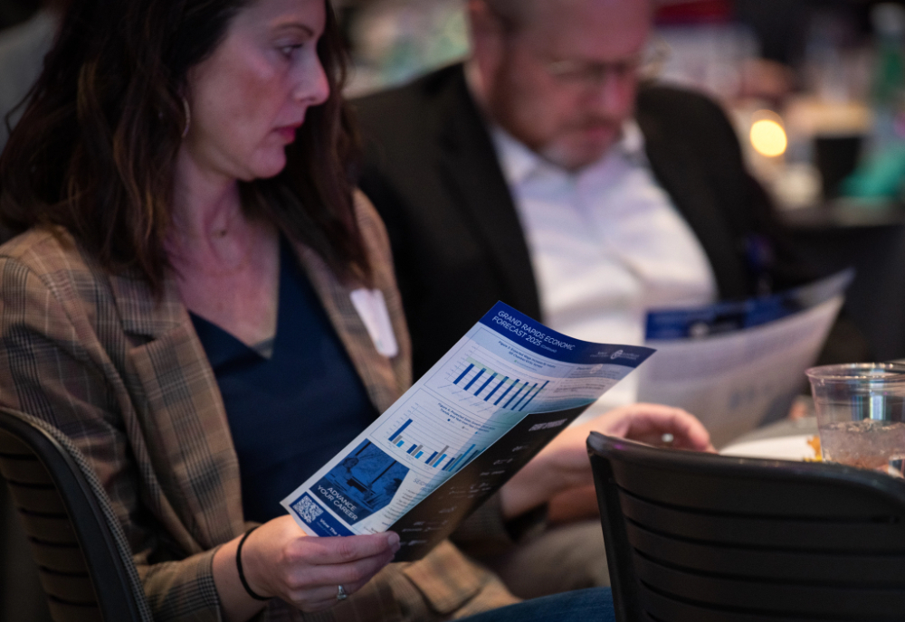 Someone looking at a finance pamphlet at an economics event.