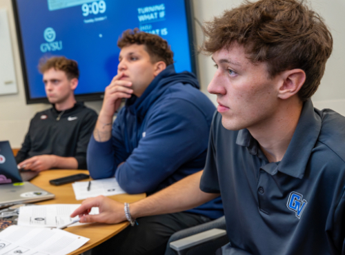 (From left) Marketing major Brendan Schultz, business administration major Isaac Hernandez and marketing major Michael Farkas listen as Mark Kubik, chair of the marketing department at the Seidman College of Business, runs through a sales scenario in the