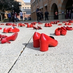 pairs of red shoes arranged in brick courtyard