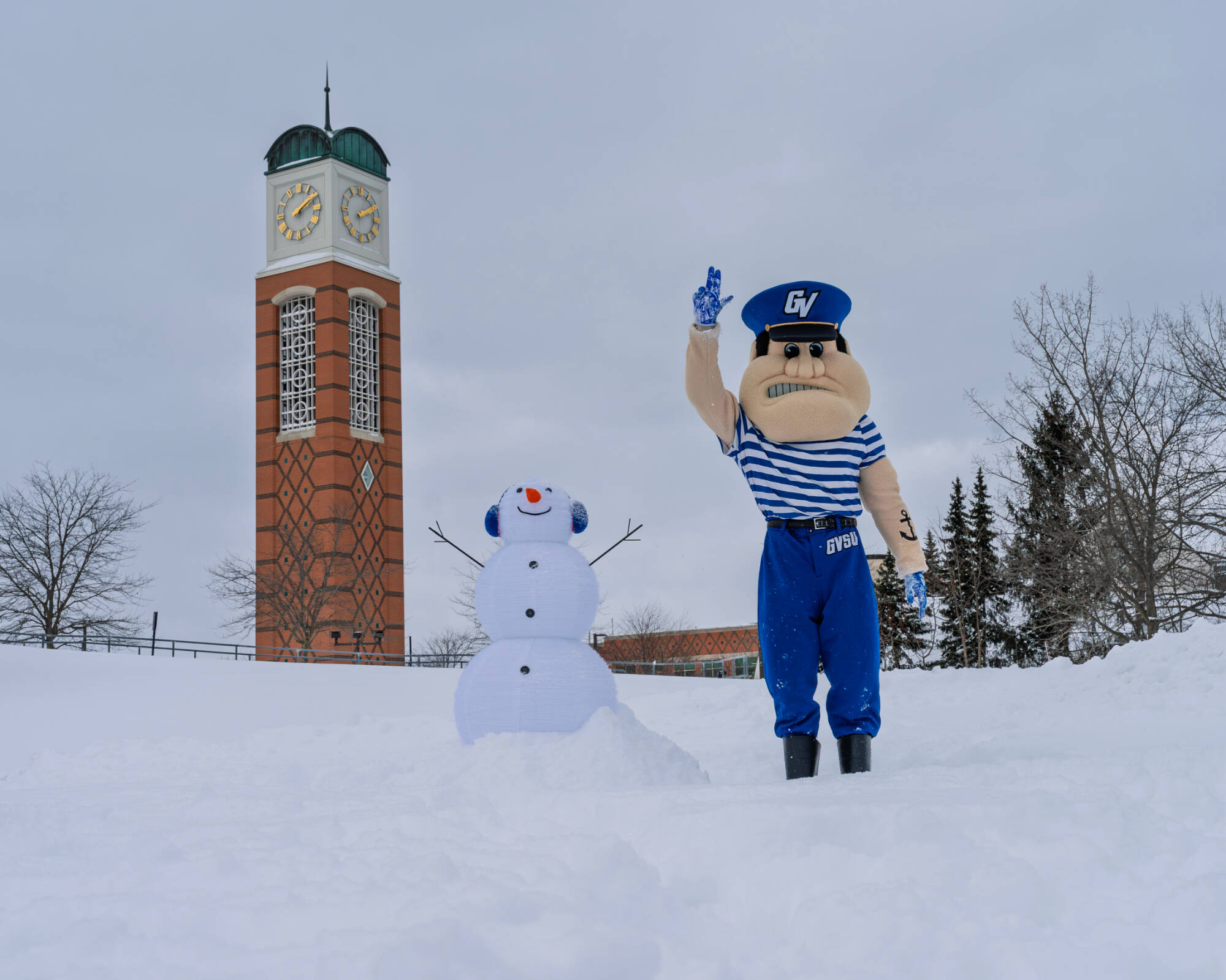 Louie the Laker next to a snowman in the snow