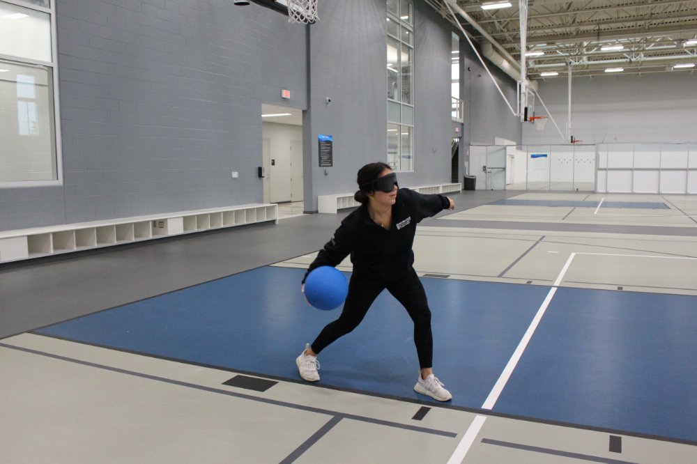 Person playing goalball, wearing an eyemask