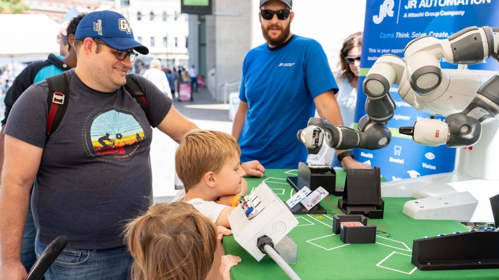 Family visiting a robotics booth at Confluence festival