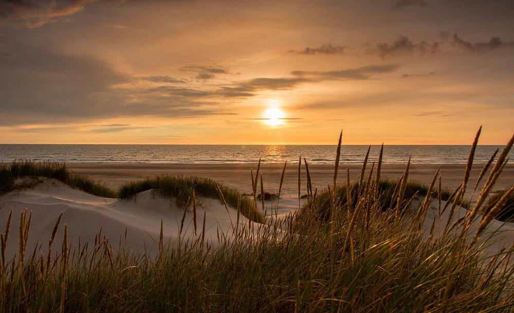 A sunset over a sand due