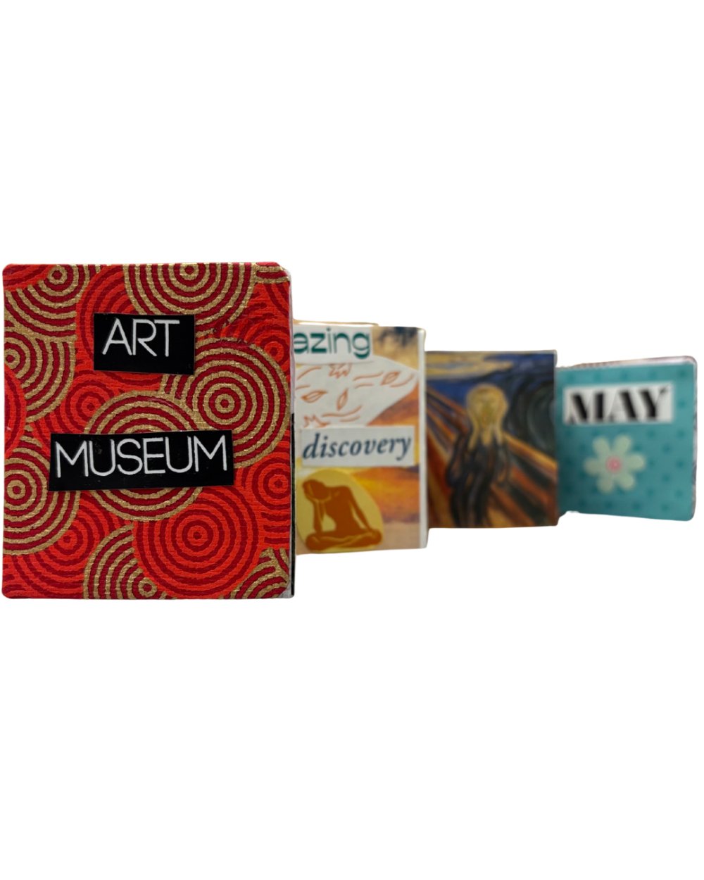 An accordion book. The cover is red and tan circles and says "Art Museum", the other pages are blurred but feature words and art.
