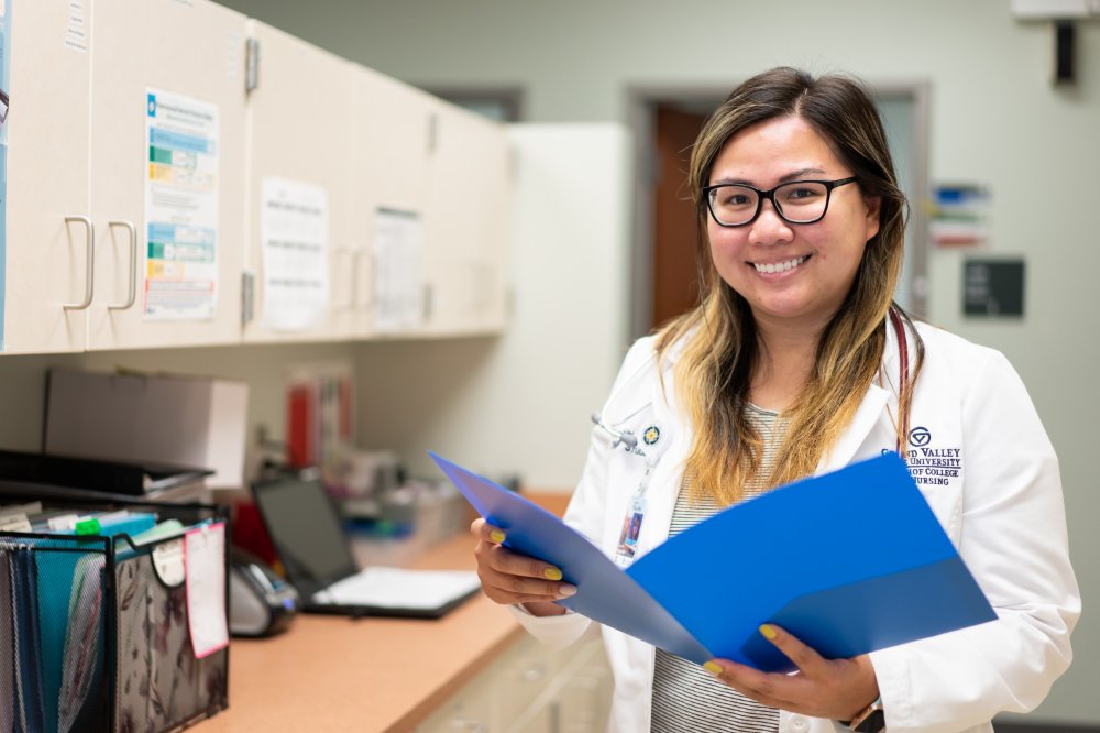 Graduate student smiling with chart