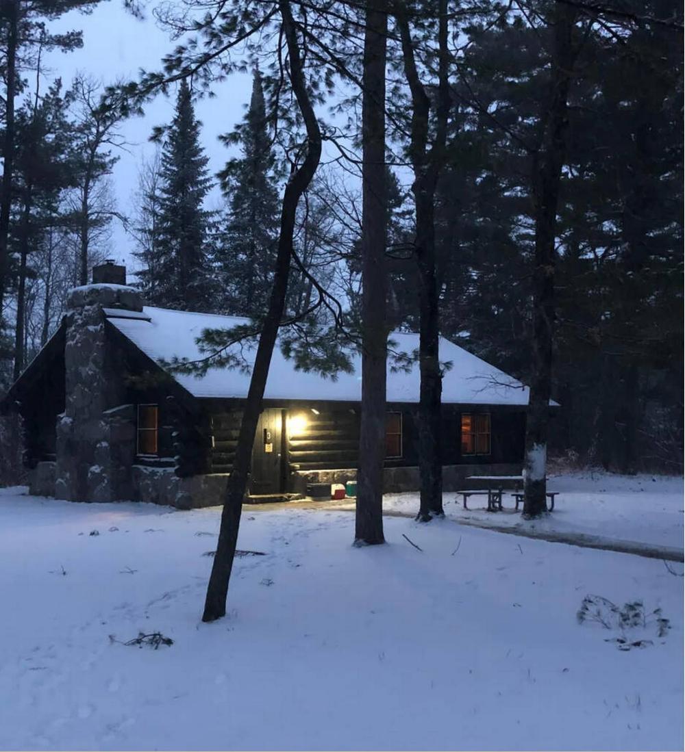 A cabin in the woods with snow on the ground
