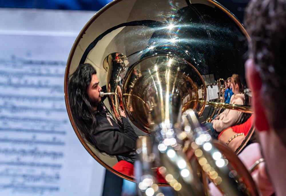Grand Valley Symphony Orchestra students Jorge Gonzalez and Elizabeth Phillips are reflected in the bell of Matthew Keith�s trombone during a rehearsal for Joel Schut�s MUS 103 class at the Louis Armstrong Theatre on February 23.