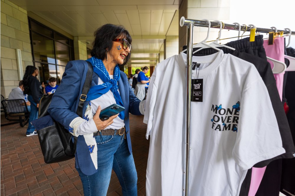President Mantella looking through a clothing rack of t-shirts