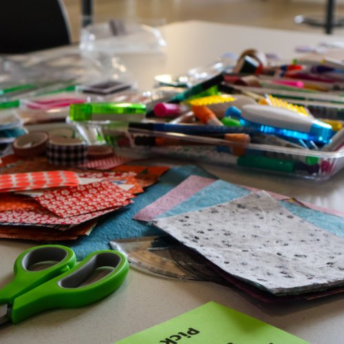 Materials for zine construction: paper, coloring pens and scissors