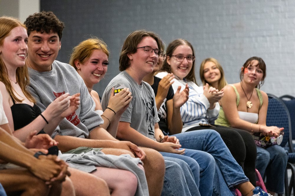 students sitting in chairs watching a performance
