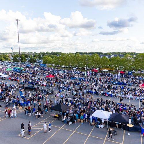 Bird's eye view of a parking lot filled with students