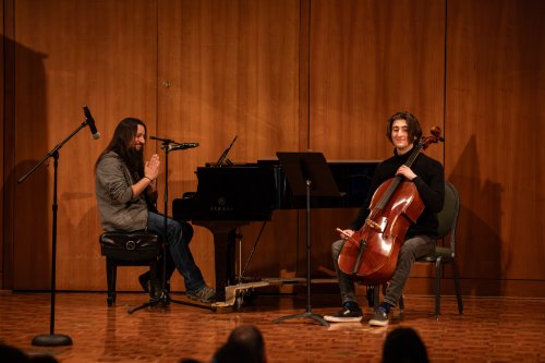 A staff member at the piano and a student holding a cello