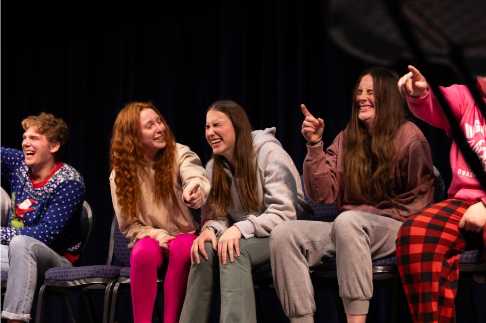 students sitting in chairs participating in show