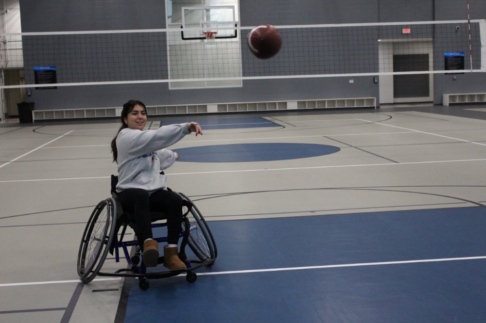 person in a wheelchair throwing a football