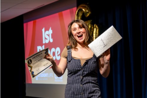 girl holding up a certificate and piece of paper