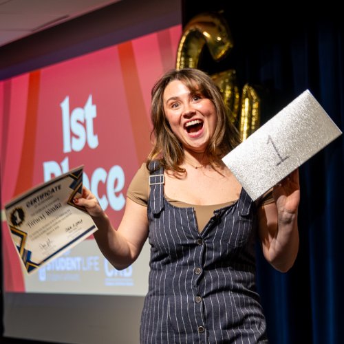 girl holding up a certificate and piece of paper
