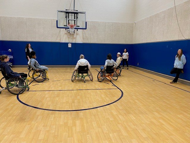 People in wheelchairs playing basketball