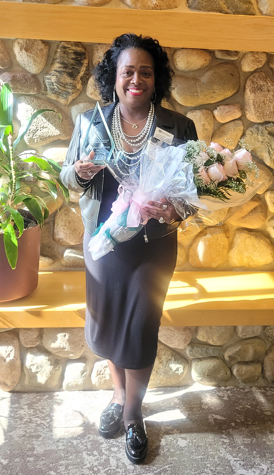 woman in front of stone fireplace holding flowers wrapped in paper