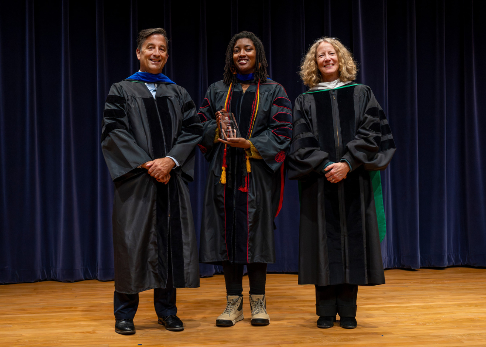 three people standing in academic regalia