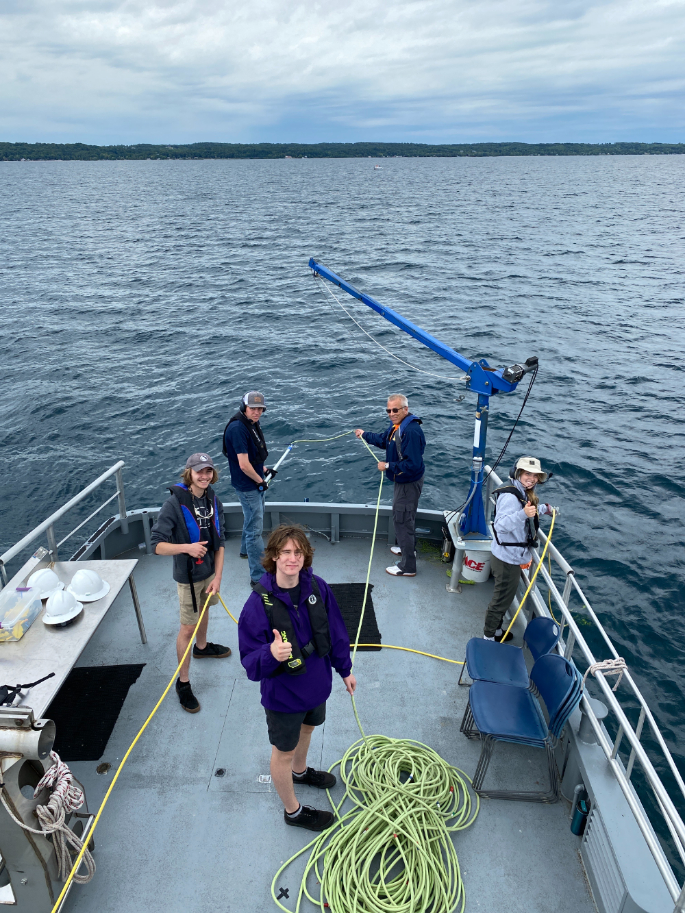 five people at the back end of a boat