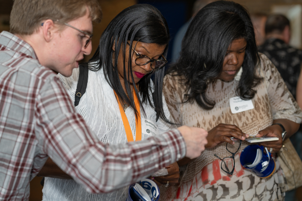 three people looking closely at gifts on a table
